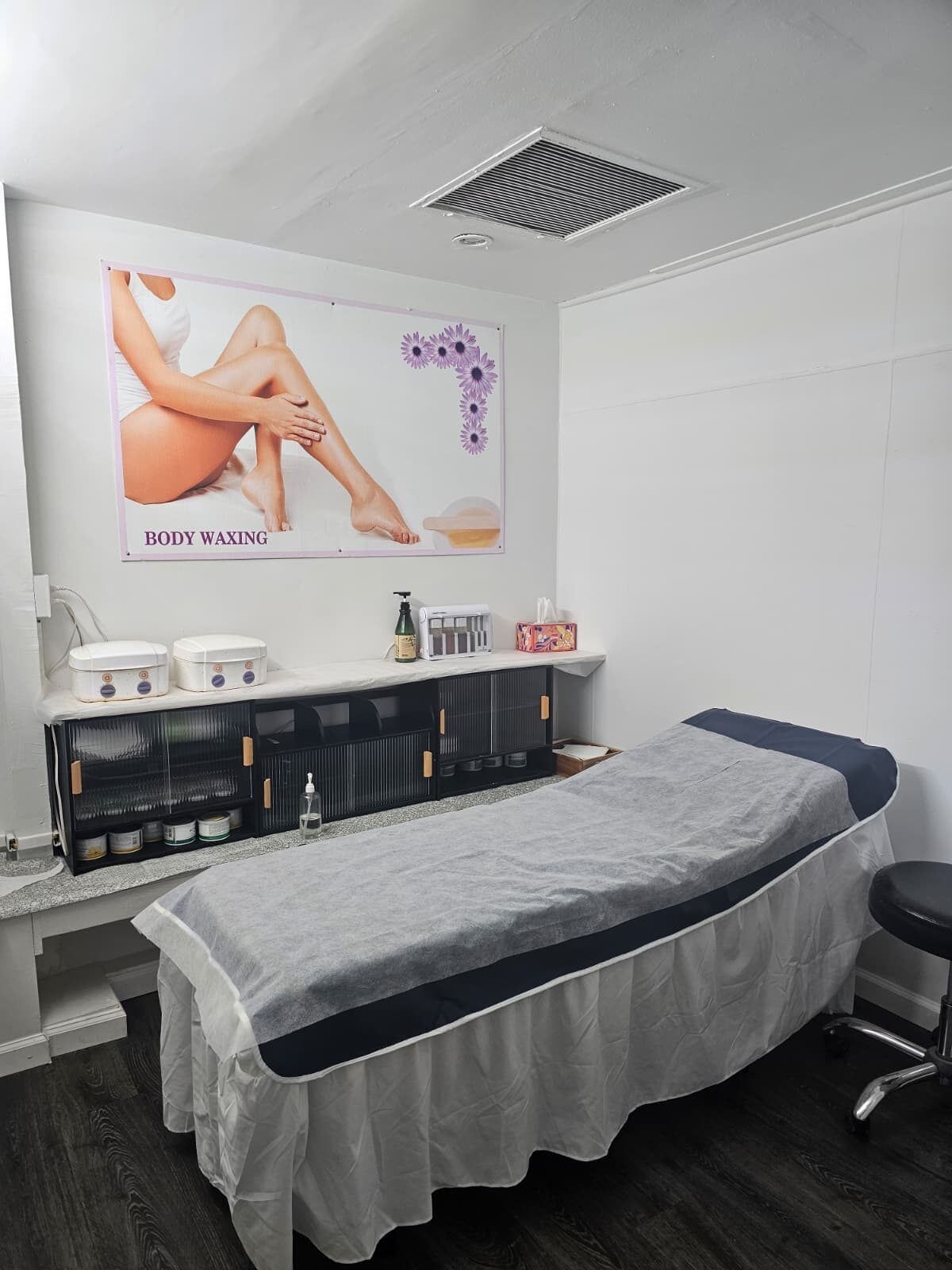 The private waxing room at Creative Brows with a treatment bed and wax warmers